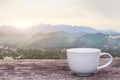 A white cup of hot espresso coffee mugs placed on a wooden floor with morning fog and moutains with sunlight background,coffee Royalty Free Stock Photo