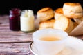 White cup of hot tea and Fresh Homemade delicious butter scones on wooden table with black background. Royalty Free Stock Photo