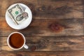 White cup with invigorating espresso coffee and saucer with two American dollar bill and coin. On dark wooden background. Payment Royalty Free Stock Photo