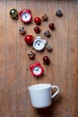 White cup on lying on side with baubles and alarm clocks