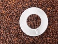 A white cup with many coffee beans