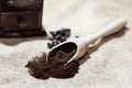 White cup and plate with beans, milling coffee and a wooden grinder on rustic background Royalty Free Stock Photo