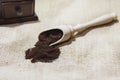 White cup and plate with beans, milling coffee and a wooden grinder on rustic background Royalty Free Stock Photo