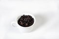 White cup with roasted coffee beans isolated with copy space