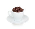 White cup and saucer filled with coffee beans Royalty Free Stock Photo