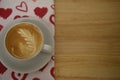 Close up drink photography of a fresh hot cup of coffee on a red love heart pattern table cloth for Valentines Day breakfast Royalty Free Stock Photo