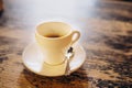 White cup with saucer and small spoon on a wooden table. Hot espresso in a white cup. Delicious coffee for breakfast in Royalty Free Stock Photo