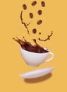 White cup of splashed coffee isolated on yellow background