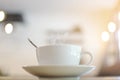White cup with steaming hot coffee on table with bokeh background at cafe. Royalty Free Stock Photo