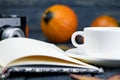 A white cup of tea coffee on a wooden background. Ripe pumpkin. Cones and leaves on a wooden table. Open notebook Royalty Free Stock Photo