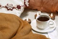 White cup of tea. Home textiles. Brown plaid, beige aroma, New Year`s decor, candles. Tinted. Space. Life stile