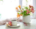 White cup with tea on the table. Flowers nearby Royalty Free Stock Photo