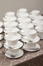 White cups for tea with spoons on table with tablecloth for coffee-break. Royalty Free Stock Photo