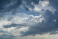 White curly clouds in a blue sky with dark clouds. Sky background. Royalty Free Stock Photo