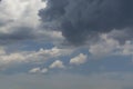 White curly clouds in a blue sky with dark clouds. Sky background. Royalty Free Stock Photo