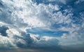 White curly clouds in a blue sky with dark clouds. Sky background. Royalty Free Stock Photo