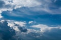 White curly clouds in a blue sky with dark clouds. Sky background. Royalty Free Stock Photo