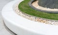White curve stone bench decorated with white gravel and lawn. for public space.