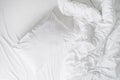 white cushion and blanket on wrinkled bed sheet, closeup Royalty Free Stock Photo