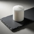 Rectangular slate base with rough edges. The candle is unlit centrally Royalty Free Stock Photo