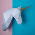 White 3d papercraft model of unicorn head on bright background. Minimal art concept