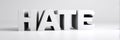 White 3D Text Word HATE Standing on White Surface Against White Background Minimalist Studio Lighting Royalty Free Stock Photo
