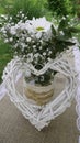 White daisy bouquet in glass jar and wattle white heart Royalty Free Stock Photo