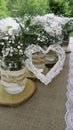 White daisy bouquets in glass jars and wattle white heart in the garden Royalty Free Stock Photo