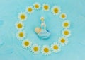 White daisy flower on blue background with baby boy statue Royalty Free Stock Photo