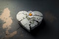 White daisy growing out of a cracked stone heart. Recovery from heartbreak concept.