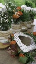 White daisy and orange roses in glass jars and wattle white heart in wreath Royalty Free Stock Photo