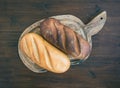 White and dark bread loafs on a rustic wooden board