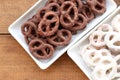 White and dark salted chocolate covered mini pretzels in a bowl on wood table. Homemade mini pretzel chip cookies on plate