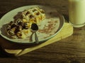 White and dark waffles with fresh warm milk top view on wooden floor