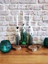 White decoration candles in vintage bottles on table