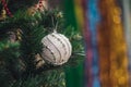White decorative ball on the christmas tree on glitter bokeh background with blurred colorful background. Merry christmas card. Royalty Free Stock Photo