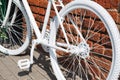 White decorative old bike with a basket of flowers against a brick wall. Copy space Royalty Free Stock Photo