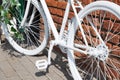 White decorative old bike with a basket of flowers against a brick wall. Copy space Royalty Free Stock Photo