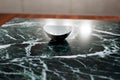 White deep small plate on a dark marble table surface in the kitchen Royalty Free Stock Photo