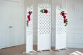 White delicate decorative wood panel in classical interior. Boudoir wedding room. Retro folding screen with flowers