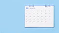 white desk calendar on blue background, planning concept.