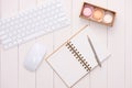 White desk with colorful macaroons, keyboard and open notebook. Royalty Free Stock Photo