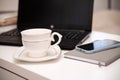 White desktop with laptop, coffee mug, phone and notebook for remote work or study. Office computer workplace in home Royalty Free Stock Photo