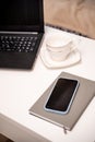 White desktop with laptop, coffee mug, phone and notebook for remote work or study. Office computer workplace in home Royalty Free Stock Photo