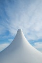 White detail of big top tent against a blue an cloudy sky