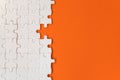 White details of puzzle on orange background Royalty Free Stock Photo