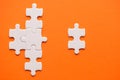 White details of puzzle on orange background Royalty Free Stock Photo