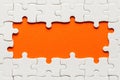 White details of puzzle on orange background and place for inscription Royalty Free Stock Photo