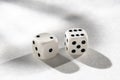 White Dice on a White Background with Harsh Shadows