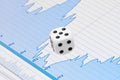 White dice on digital screen with financial chart